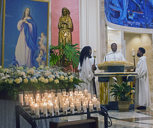 Father Reynold Brevil, parochial vicar at St. Mary Cathedral, proclaims the Gospel on the feast of the Assumption, Aug. 15, 2021, a day after a 7.2 earthquake killed nearly 1,300 people in Haiti's southwestern peninsula. Archbishop Thomas Wenski celebrated the Mass to pray especially for the earthquake victims.