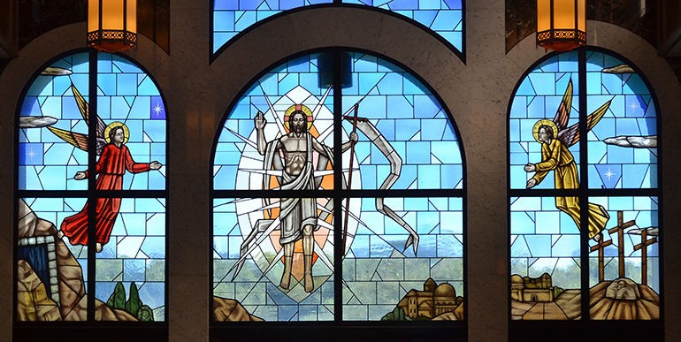 Jesus rises from the grave, flanked by angels, in this triple-wide window at Our Lady Queen of Peace Cemetery in North Lauderdale.