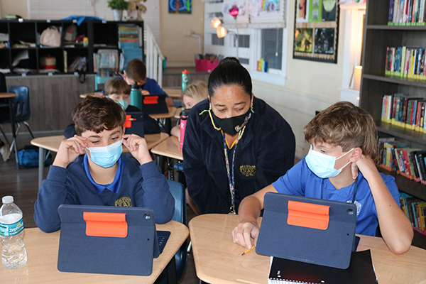 Gaudy Herring, a Spanish teacher at St. Anthony School, works with her students. The students use Apple technology in the classroom and all around the campus. "I love it," she says. "We have gone completely paperless."