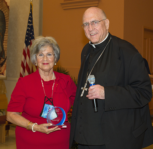 Isabel Font of St. Martin de Porres Parish in southern Miami-Dade County, receives a Walking with Moms award from Archbishop Joseph H. Naumann, chairman of the U.S. bishops' Committee on Pro-Life Activities, during the second night of the Congreso Pro Vida, Oct. 30, 2021.