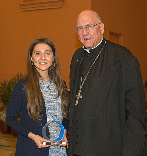 Mariana Barbara, of FIU Catholic Panthers, receives a Walking with Moms award from Archbishop Joseph H. Naumann, chairman of the U.S. bishops' Committee on Pro-Life Activities, during the second night of the Congreso Pro Vida, Oct. 30, 2021.