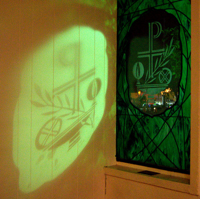 By night, a window etching casts an image on a wall.