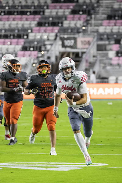 Cardinal Gibbons quarterback Dylan Rizk (10) runs the ball during  the Class 4A State Championship game between Cardinal Gibbons and Cocoa Beach at DRV PNK Stadium in Fort Lauderdale, Dec. 16, 2021.