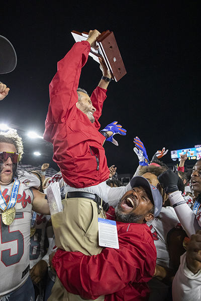 Cardinal Gibbons coaching staff celebrate at the conclusion of the Class 4A State Championship game between Cardinal Gibbons and Cocoa Beach at DRV PNK Stadium in Fort Lauderdale, Dec. 16, 2021.