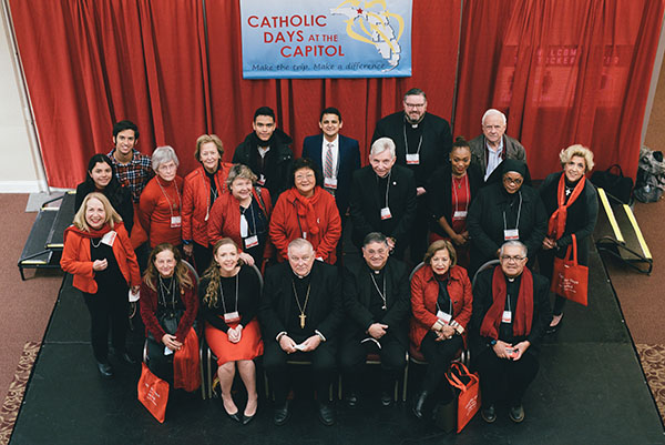 The delegation from the Archdiocese of Miami pose for a group photo with Archbishop Thomas Wenski, bottom row, third from left, and Auxiliary Bishop Enrique Delgado following a breakfast Feb. 2, 2022, at Catholic Days at the Capitol. Traditionally, participants wear red during the event held in Tallahassee, which closes with an annual Red Mass.