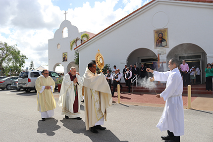 Father Giovanni Peña, pastor of Prince of Peace Parish in Miami, carries the Blessed Sacrament in procession from the church to the new chapel of St. Joseph, located on one side of the church. He is accompanied by Archbishop Thomas Wenski, concelebrating priests, parish Knights of Columbus and others who took part in the dedication Mass, March 19, 2022.