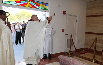 Archbishop Thomas Wenski blesses the new chapel of St. Joseph at Prince of Peace Parish on the saint's feast day, March 19, 2022. He is accompanied, at left, by Prince of Peace's pastor, Father Giovanni Peña, other priests who concelebrated the dedication Mass and parishioners who took part in it.