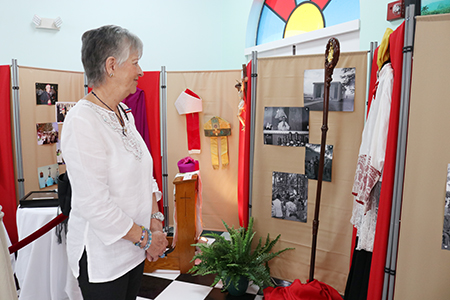 Olga Pérez, integrante de la Archicofradía de la Ermita de la Caridad, mira algunos objetos personales de Mons. Agustín Román que fueron expuestos en la Ermita por el 10 aniversario de su muerte.