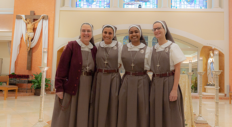 Mother Adela Galindo, foundress of the Servants of the Pierced Hearts of Jesus and Mary, poses with the three newly professed sisters after the ceremony, May 31, 2022 at Our Lady of Lourdes Church, Miami. From left: Mother Adela, Sister Maria Inmaculada, Sister Rachel Lucia and Sister Marie Elizabeth.