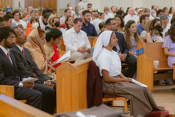 Sister Rachel Lucia listens attentively to the readings as her parents and siblings behind her do the same during the Mass where she and two others professed first vows in the Servants of the Pierced Hearts of Jesus and Mary, May 31, 2022 at Our Lady of Lourdes Church, Miami.
