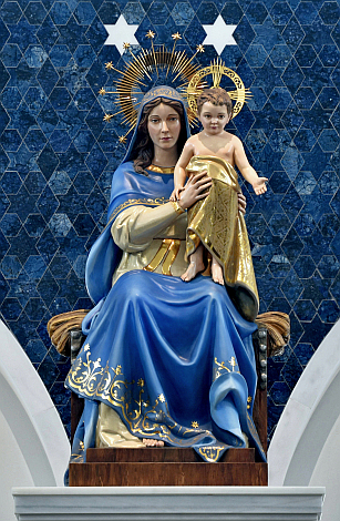 La estatua de Nuestra Señora de Belén parece vestida con tela, pero está artísticamente tallada y tratada en madera.