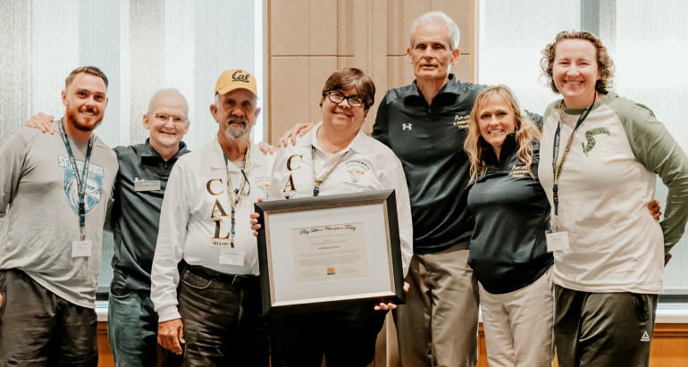 Valarie Lloyd, holding plaque, and Frank Ramos, in yellow cap, join other Miami-area trainers for their award on behalf of the Archdiocese of Miami at the 2022 Play Like a Champion Sports Leadership Conference.