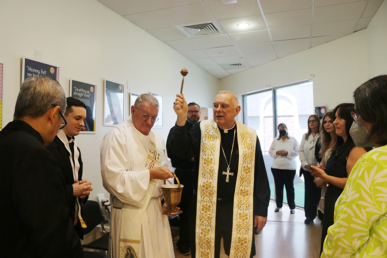 El Arzobispo Thomas Wenski bendice el nuevo centro de Ayuda al Embarazo del ministerio de Respeto a la Vida localizado en Fort Lauderdale, el 13 de agosto. Lo acompañan desde la izquierda: el P. Edgardo De Los Santos, administrador de la parroquia St. John the Baptist en Fort Lauderdale; el P. Michael García, párroco de la iglesia St. Coleman en Pompano Beach; el diácono James Dugard a cargo del Ministerio de Respeto a la Vida; el P. Ryan Saunders, sacerdote secretario del Arzobispo y el personal y voluntarios del ministerio de Respeto a la Vida de la Arquidiócesis de Miami.