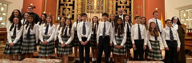 The 20 students from St. Theresa School in Coral Gables who were inducted into the National Junior Honor Society pose with their principal, Carmelite Sister Rosalie Nagy, right, parochial vicar, Father Andrew Tomonto, left, and Daniel Serrano, center rear, NJHS moderator and social studies teacher.