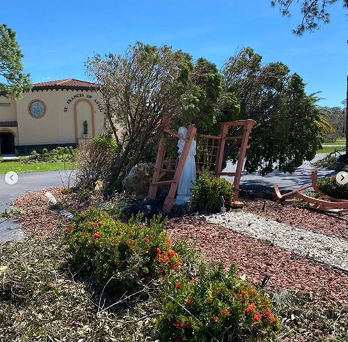 Trees and shrubs are bent sideways after the passage of Hurricane Ian at St. Francis of Assisi Parish in Grove City (Englewood area), which also sustained roof damage to the church and parish hall.