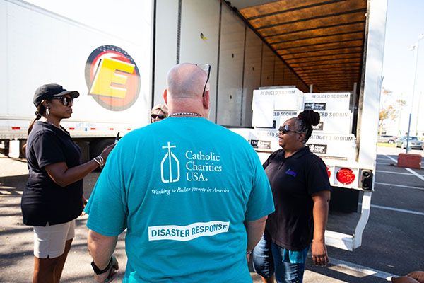 At the Elizabeth Kay Galeana Catholic Charities Center in Fort Myers, staff and volunteers with Catholic Charities of the Diocese of Venice unload trucks with emergency foodstuffs for a distribution there following Hurricane Ian, Oct. 5, 2022.