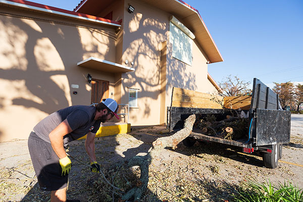 A worker cleans up the grounds of St. Francis Xavier Parish in Fort Myers on Oct. 5, 2022, following the passage of Hurricane Ian.