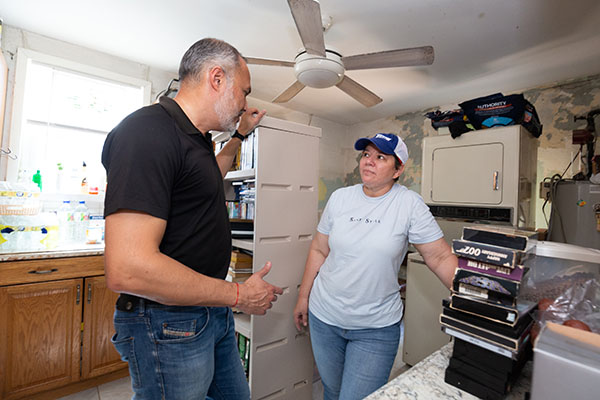 Eddie Gloria, CEO of Catholic Charities of the Diocese of Venice, meets with Elizabeth Reyes on Oct. 5, 2022 after Hurricane Ian brought at least three inches of rain into the family's residence in Fort Myers on Sept. 28.