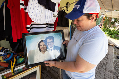 Fort Myers resident and art instructor Elizabeth Reyes inspects her parent's wedding memorabilia, salvaged from her home on Oct. 5, 2022, after Hurricane Ian brought at least three inches of rain into the family's residence on Sept. 28. A fallen tree also pulled the power line from the home. Reyes and her husband have been living in a rental property in Naples after Ian landed on Florida’s Southwest coast as a strong Category 4 storm.