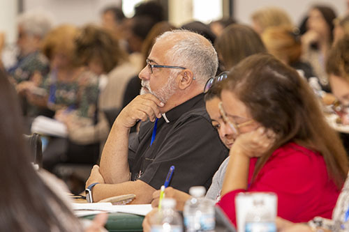 Father Juan Hernández and his staff from Mother of Our Redeemer Parish in Miami listen to Joshua Danis, national director for Alpha USA, during the opening session of Bridging the Gap, a professional development day that brought around 250 parish staff members, volunteers, school principals and priests to Msgr. Edward Pace High School in Miami Gardens, Oct. 11, 2022.