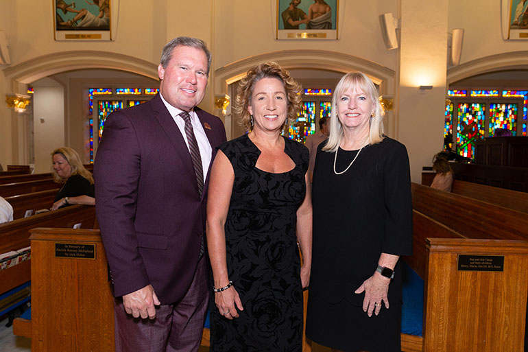 David A. Armstrong, presidente de la Universidad St. Thomas en Miami Gardens, posa con su esposa, Leslie Armstrong (centro), y Gail Bulfin, después de la 31 Misa Roja anual de la Sociedad Santo Tomás Moro del Sur de La Florida, el 18 de octubre de 2022, en la iglesia St. Anthony en Fort Lauderdale.