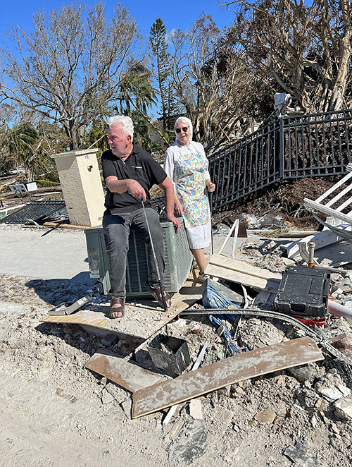 Debris surround Father William Adams and Poor Clare Abbess Sister Mary Frances of Jesus Fortin as they are seen on the property of Ascension Parish and San Damiano Monastery on Fort Myers Beach  Oct. 1, 2022, destroyed by the storm surge of Hurricane Ian.