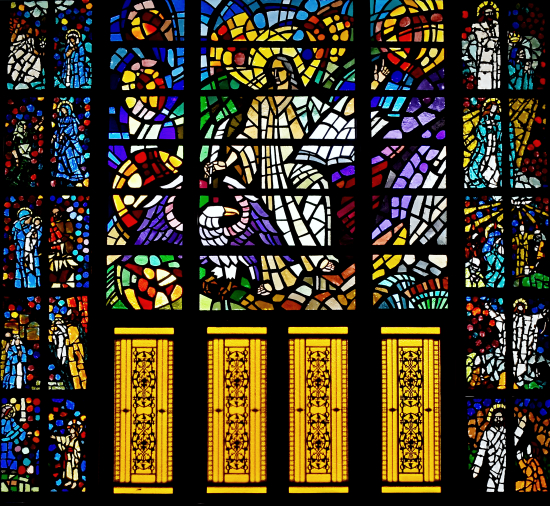 Above the four doors of the front entrance is a huge faceted glass window of St. John, with his symbolic eagle.  Flanking the main window are 10 smaller ones depicting episodes from his gospel.