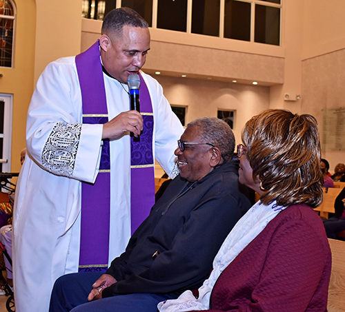 Father Sidney Speaks jokes with a congregant during a revival Feb. 9, 2023 at the St. Anthony Chapel of St. Thomas University.