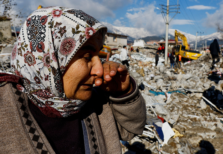 An earthquake survivor cries while standing amid rubble in Hatay, Turkey, Feb.7, 2023. A powerful 7.8 magnitude earthquake rocked areas of Turkey and Syria early Feb. 6, toppling hundreds of buildings and killing thousands. (OSV News photo/Umit Bektas, Reuters)