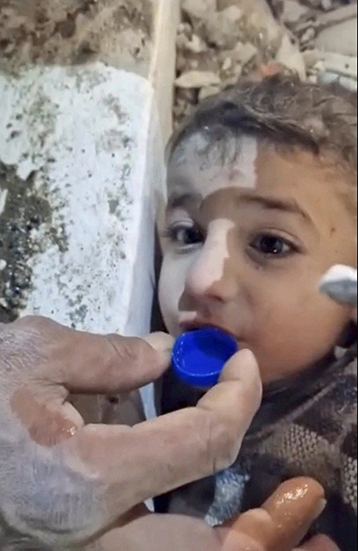 Rescuers give a young earthquake survivor water in a bottle cap as they rescue him from the rubble in Hatay, Turkey Feb. 7, 2023, in this still image taken from video. The powerful 7.8 magnitude earthquake rocked areas of Turkey and Syria early Feb. 6, toppling hundreds of buildings and killing thousands. (OSV News photo/Istanbul Municipality handout via Reuters)