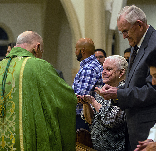 Archbishop Thomas Wenski gives Communion to Marta and Pedro Pelaez, married 66 years, during the annual Mass honoring sacramental marriage and couples celebrating milestone anniversaries. The Mass was celebrated Feb. 18, 2023 at St. Mary Cathedral in Miami.