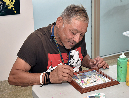 "Painting transports me to another place, another dimension," says Oscar Guzman, who takes part in the art therapy program at Camillus House.