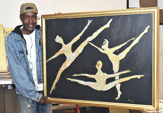 Barry Glenn shows one of his earlier paintings of dancers, in the art therapy program at Camillus House.
