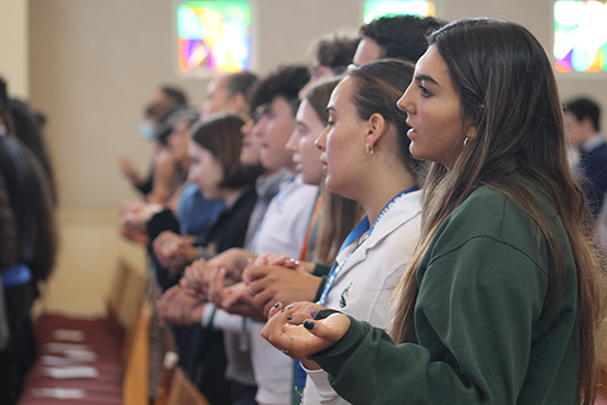 Students from Immaculata La-Salle High and other Archdiocese of Miami high schools hold hands during the Lord's Prayer at a Mass at St. Anthony Chapel at St. Thomas University in Miami Gardens on March 22, 2023. Earlier in the day, students participated in a kick-off gathering for the National Eucharistic Revival.