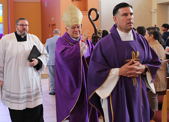 Archbishop Thomas Wenski, center, blesses students and faculty from Archdiocese of Miami high schools as he processes out of the Chapel of St. Anthony at St. Thomas University. Accompanying him are Father Rafael Capo, right, vice president for Mission at STU, and Father Ryan Saunders, priest-secretary to the archbishop.