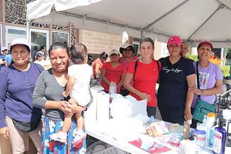 Volunteers from St. Jerome Parish in Fort Lauderdale pose for a photo on April 22, 2023, while distributing relief items to people living near the parish who were affected by April 12, 2023 flooding in Broward County. From  left, Aleida Mendoza, flood victim Carla Garza, Xiomara Petit, Vicky Sánchez, and Miriam Moradel.