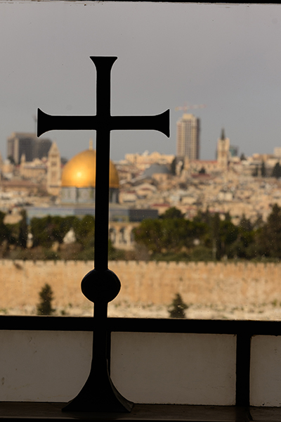 A cross overlooks the Dome of the Rock in Jerusalem, a city that is considered holy land by all three of the Abrahamic faiths: Jews, Christians and Muslims.