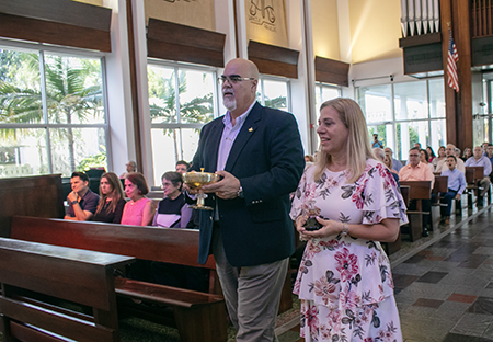 Laura y Fernando Gómez, coordinadores del movimiento Camino del Matrimonio portan el ofertorio durante la Misa por los 50 años del movimiento en la Arquidiócesis de Miami, el 16 de abril, en la capilla del Seminario St. John Vianney.