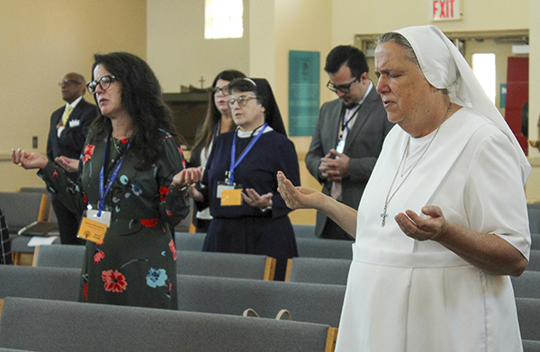 Principals from Archdiocese of Miami Catholic schools pray during a Mass celebrating the Archdiocese of Miami Office of Schools' final meeting of school principals on April 27, 2023 at Archbishop Edward McCarthy High School in Southwest Ranches.