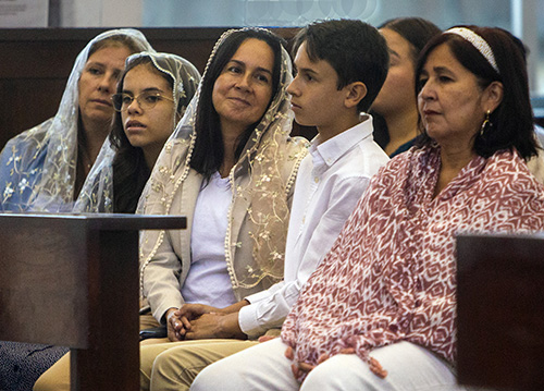 Listening to the homily at the Serra Club's annual Altar Server Awards ceremony, April 30, 2023, from left: Elisabeth Klug-Pulido, Daniela Pulido, Maria Fernanda Castellanos, and her son and altar server, Mateo Otero, 12, and Maria Pilar-Nunez. 
Miami Auxiliary Bishop Enrique Delgado celebrated Mass and handed out the awards along with Father Matthew Gomez, archdiocesan vocations director, at St. Raphael Chapel on the campus of St. John Vianney College Seminary in Miami.