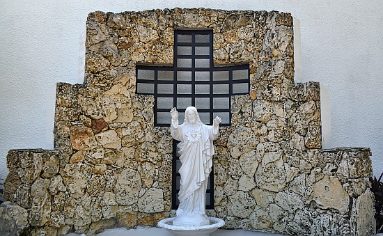 Statue of Jesus' Sacred Heart, backed by a cross in a lattice frame, takes the center of this coral display at St. Boniface Church, Pembroke Pines.