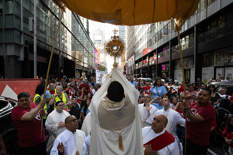 A clergyman elevates a monstrance in a Eucharistic procession through the Manhattan borough of New York City to St. Patrick's Cathedral for a Pentecost Vigil May 27, 2023. The Charismatic Renewal event in Spanish attracted close to 2,700 people. (OSV News photo/Jeffrey Bruno)