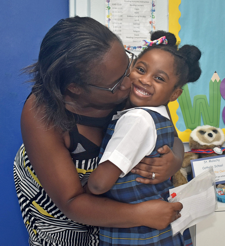 Aaliyah Jeannitton got a big squeezy good-bye kiss from her mother, Sophia, on her first day in kindergarten at St. Malachy School, Tamarac, Aug. 16, 2023.