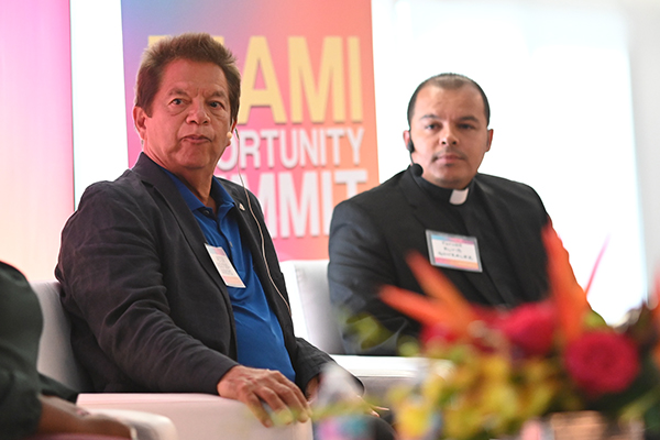 Peter Routsis-Arroyo, CEO of Catholic Charities of the Archdiocese of Miami, and Father Elvis Gonzalez, pastor of St. Michael the Archangel Church in Miami, take part in one of the panel discussions at the Miami Opportunity Summit: Immigrant Contributions and Bipartisan Solutions, held Aug. 22, 2023.