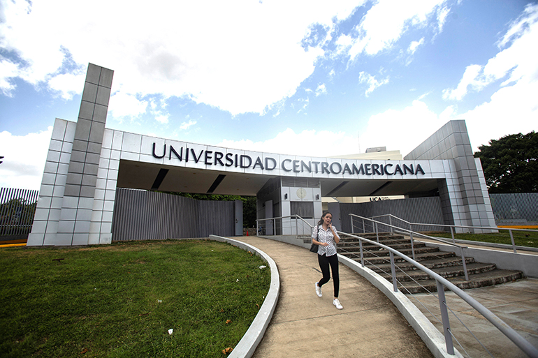 Una mujer sale del edificio de la Universidad Centroamericana en Managua, Nicaragua, el 16 de agosto de 2023. La universidad se vio forzada a suspender sus actividades el 16 de agosto, después de que las autoridades nicaragüenses acusaran al centro de estudios de ser un "centro de terrorismo" y ordenaran la expropiación de sus bienes.