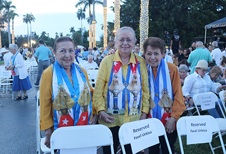 Desde la izquierda, las hermanas Oneida Collado, Orfelina Collado y Dalia Denkas, integrantes de la Archicofradía de la Virgen de la Caridad de Miami, esperan el inicio de la celebración de la Virgen de la Caridad de este año, en el Santuario de la Ermita de la Caridad, en Miami, el 8 de septiembre.