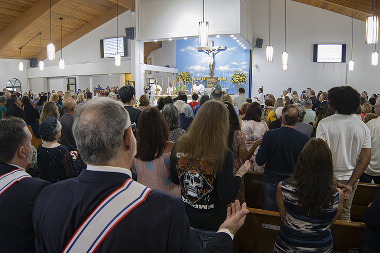Los fieles rezan el Padre Nuestro en la Misa para celebrar el 50 aniversario de la iglesia St. Benedict, el 23 de septiembre de 2023.