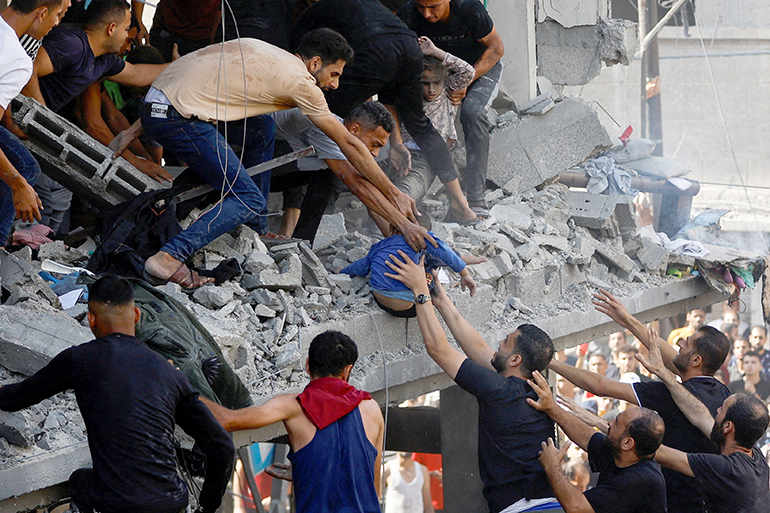 Palestinians attend to a child who was a casualty of an Israeli airstrike on a house in Khan Younis, in the southern Gaza Strip, Oct. 24, 2023. (OSV News photo/Ibraheem Abu Mustafa, Reuters)