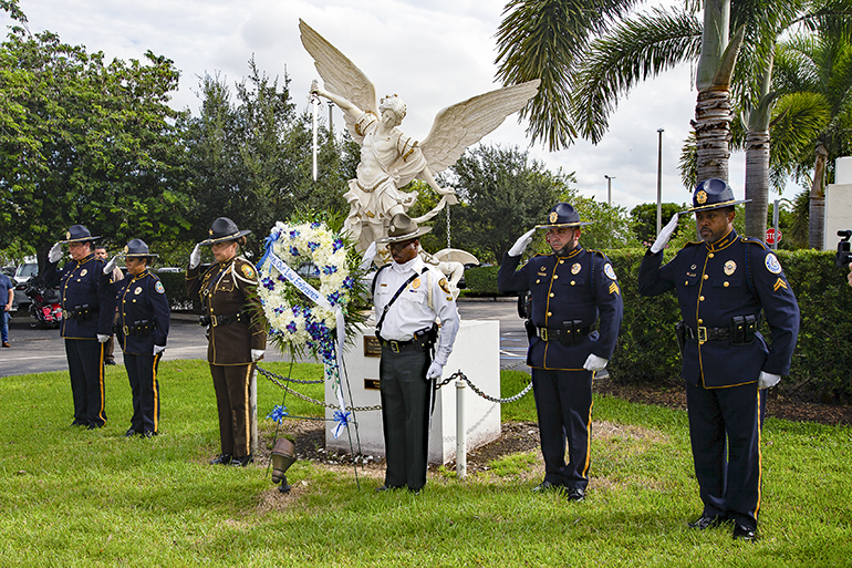 A multi-agency police honor guard salutes after placing a wreath below the statue of St. Michael outside Our Lady of Guadalupe Church in Doral immediately after the Blue Mass, celebrated Sept. 29, 2023, feast of St. Michael the Archangel.