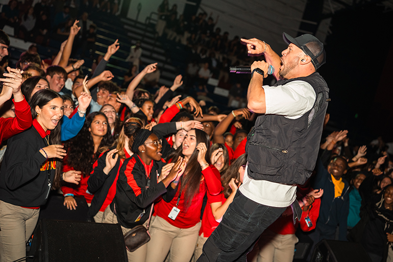 Students from archdiocesan high schools sway to the beat of Catholic speaker and recording artist Joe Melendrez during "Rise Up for a Revival" at St. Thomas University, Oct. 5, 2023.
